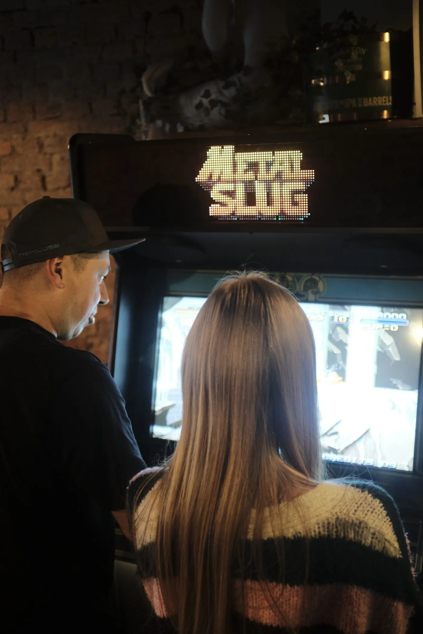 Goście eventu grający na automacie arcade